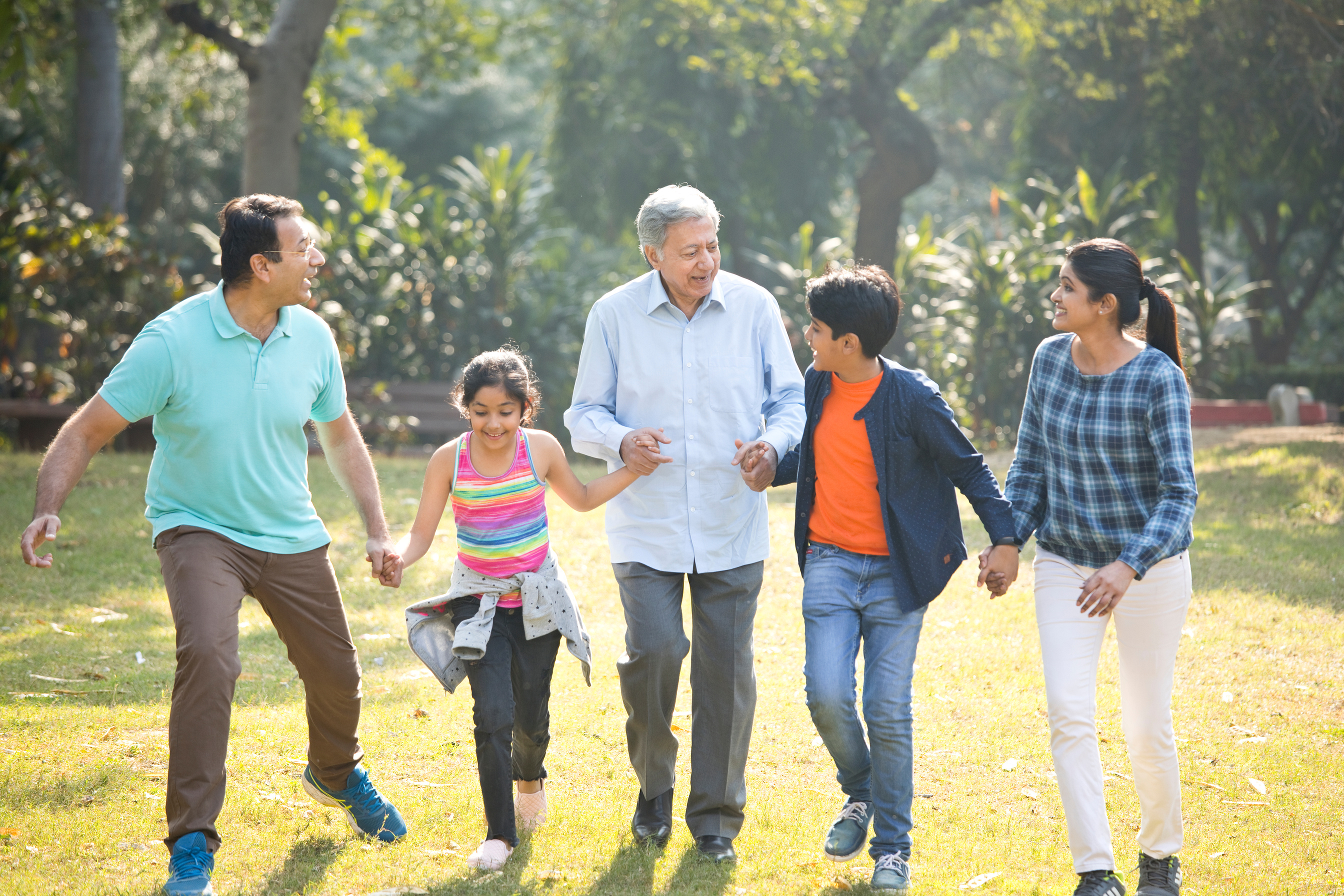 Multi generation Indian family running at park